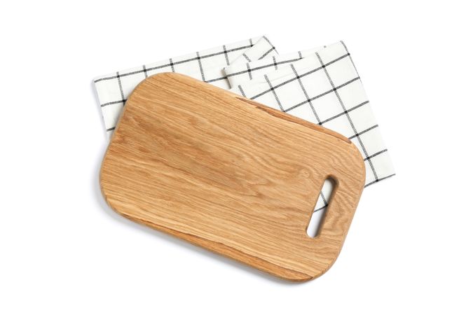 Cutting board with kitchen towel isolated on studio background, top view