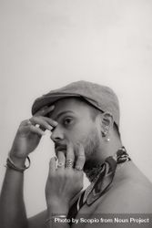 Grayscale photo of topless man wearing hat and jewelry 0KRR7b
