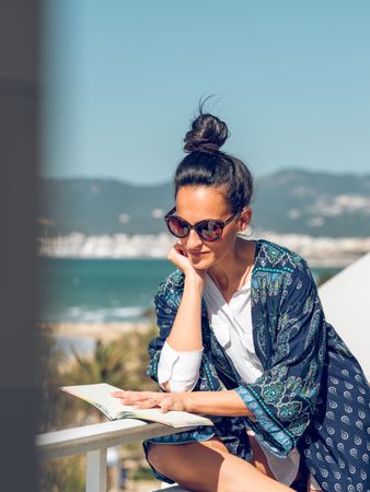 Woman reading book on terrace