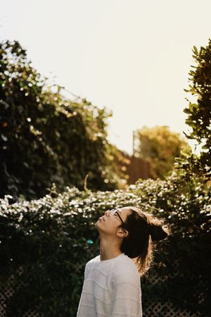Young woman looking up in yard