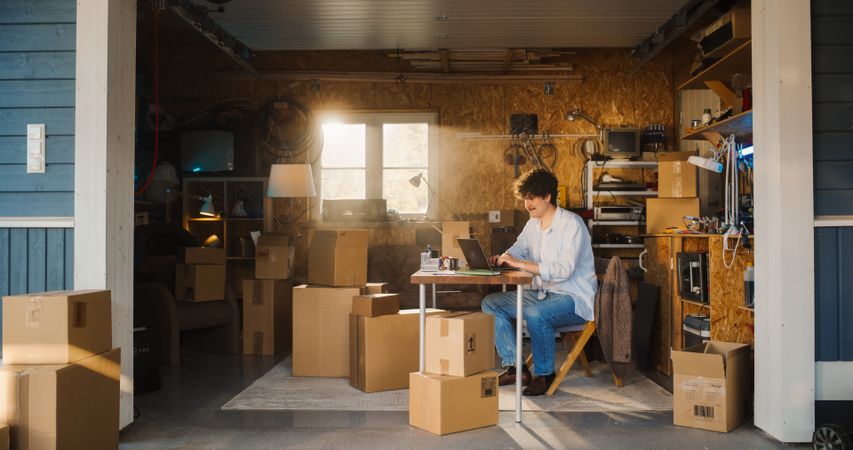 White Businessman Using Laptop Computer In Garage.