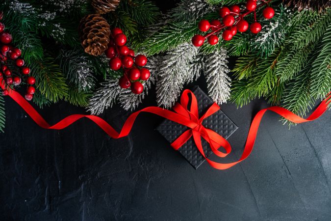 Christmas frame concept of branch with gift box on concrete background