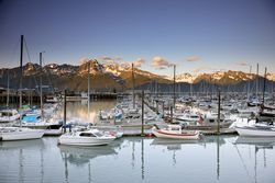Boat marina with mountains in evening light in Alaska QbDlkb