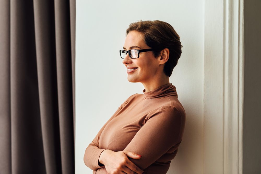Happy female wearing eyeglasses looking away