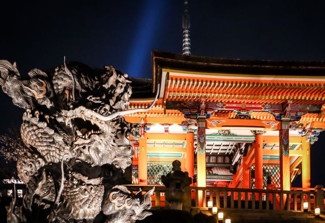 Japanese style building beside a dragon statue at night