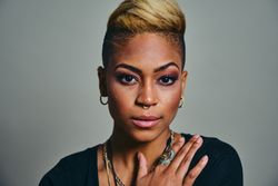 Closeup portrait of serious Black woman with septum piercing with hand to her chest