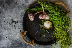 Top view of cooking concept with marjoram and garlic on plate