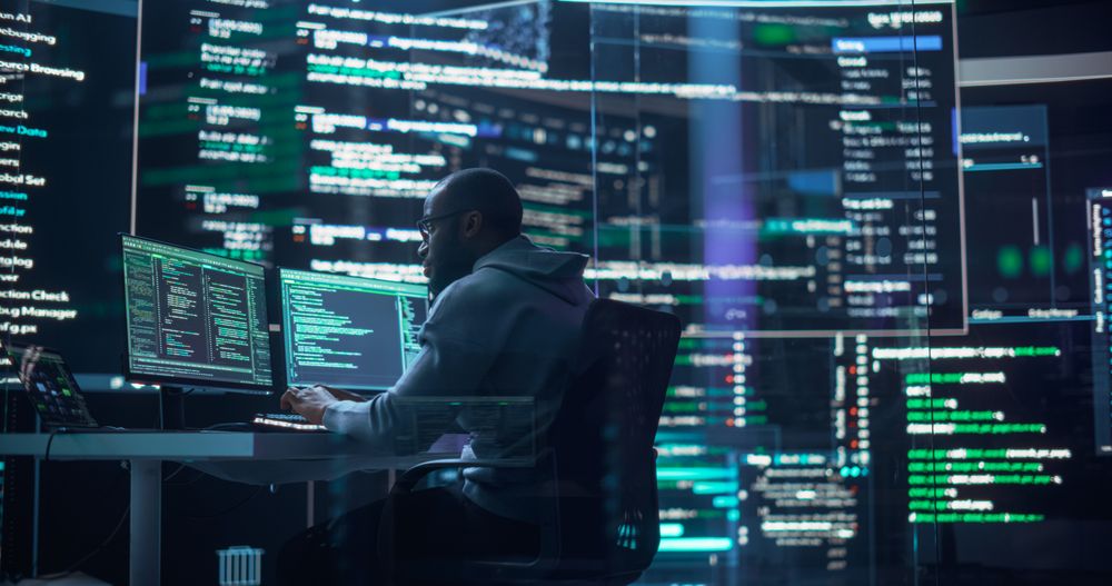 Shot of a Man Working as a Developer, Surrounded by Big Screens Displaying Lines of Code in a Monitoring Room.