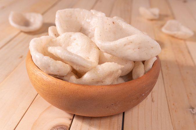 Crispy traditional crackers (kerupuk) served in a wooden bowl
