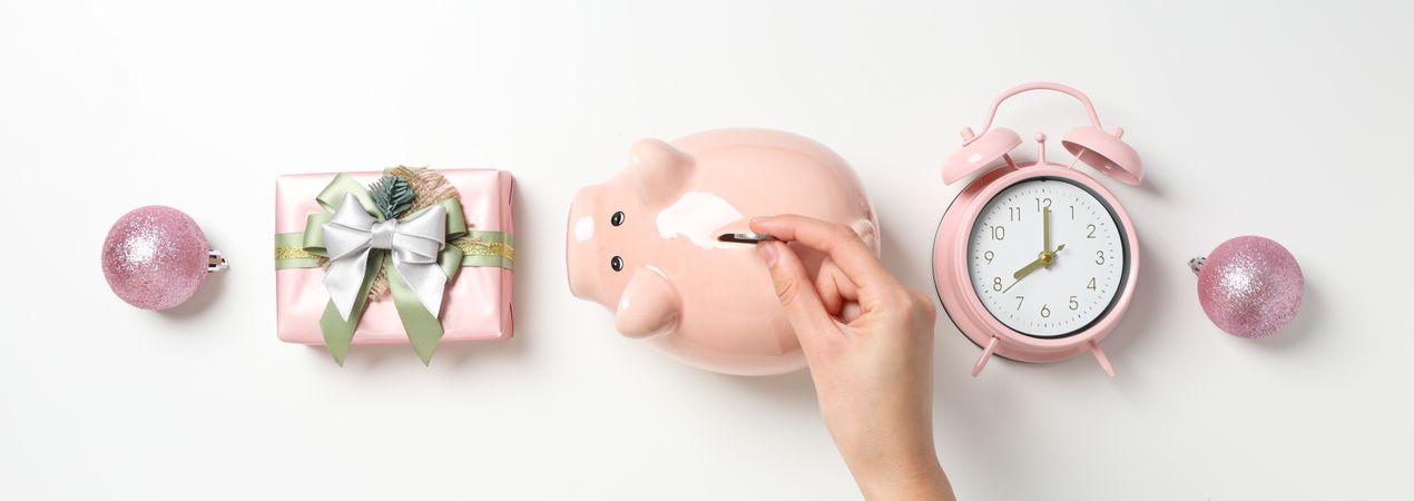 Piggy bank, hand with coin, gift box and clock on blank background, top view