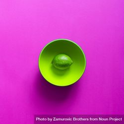 Lime in green bowl on purple background 5pppN5