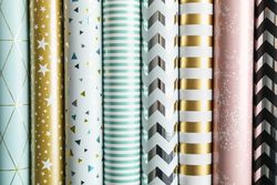 Rolls of festive wrapping paper as background. Top view