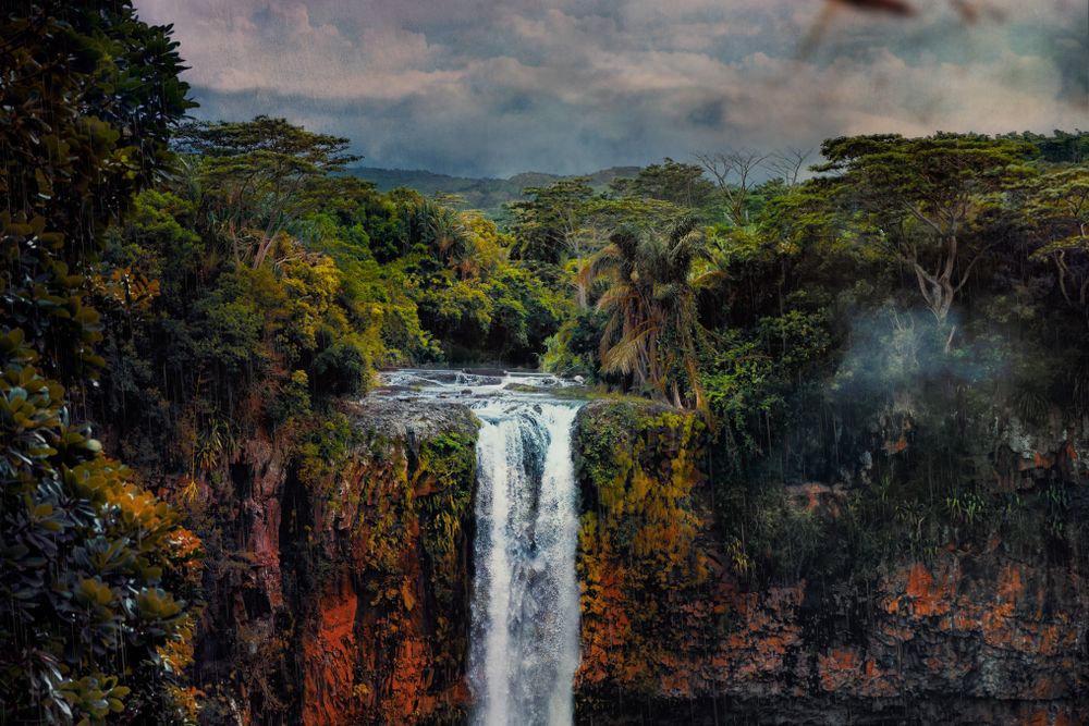 Waterfall surrounded by colorful rocks and vegetation