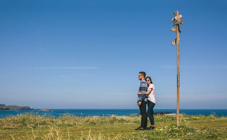 Couple embraced by a direction sign