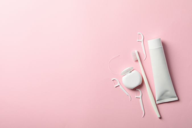 Tools for dental care on pink background, space for text