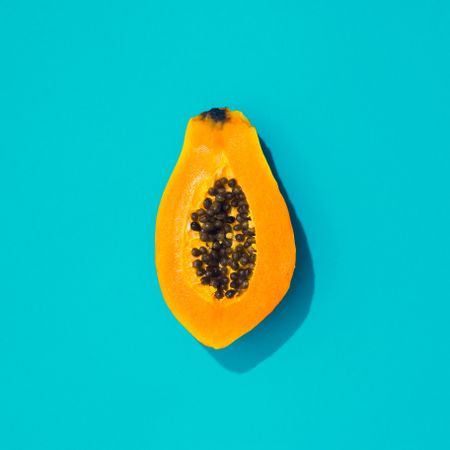 Papaya half on bright blue background