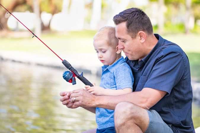 Young Father and Son Having Fun Fishing At The Lake