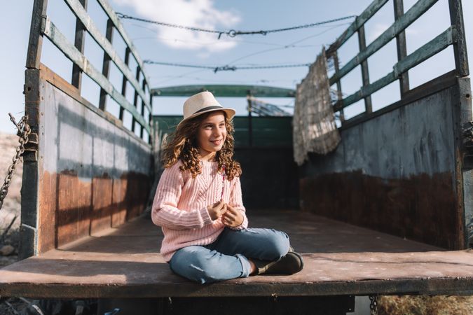 Focused girl resting in truck body