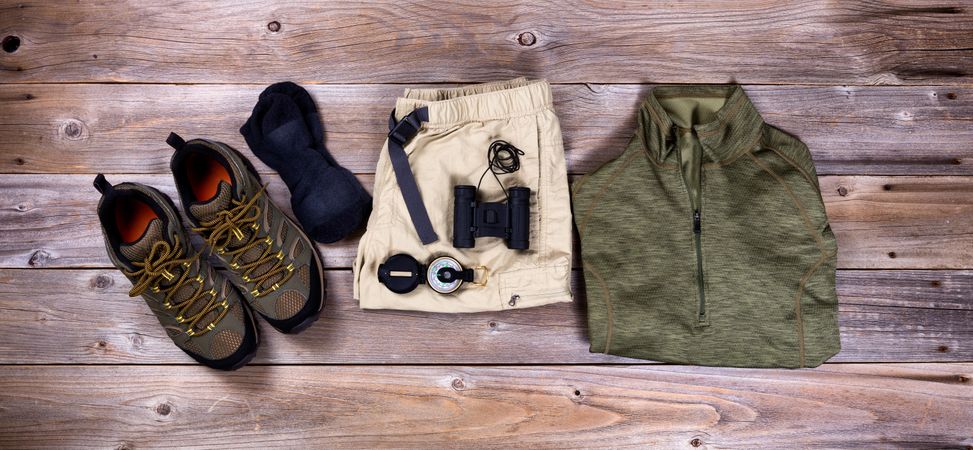 Hiking gear and clothing on rustic wood