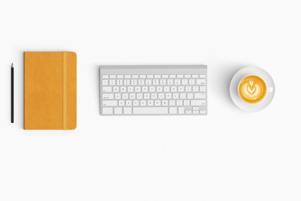 Modern workspace with coffee cup, paper, notebook