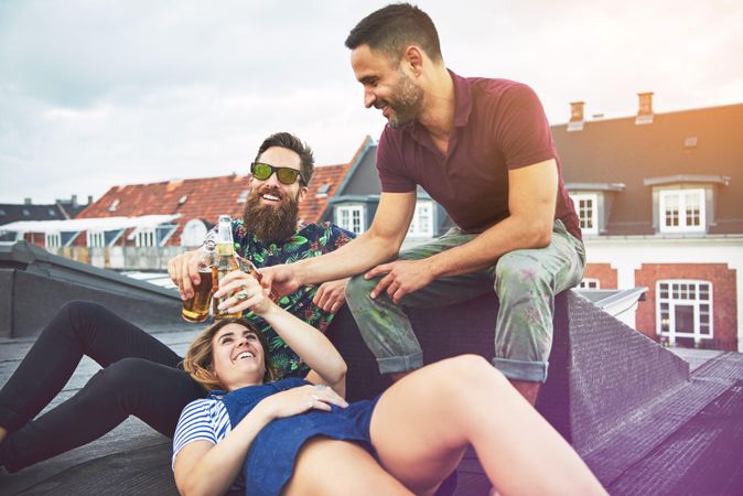 Group of people hanging out and lounging with beer on a roof