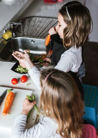 Siblings preparing vegetables for salad