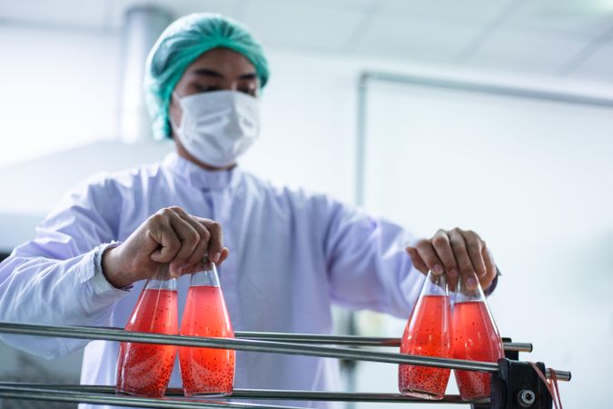 Man working with juice bottled in factory