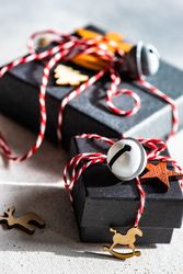 Close up of Christmas gift boxes with holiday decor on stone background with copy space