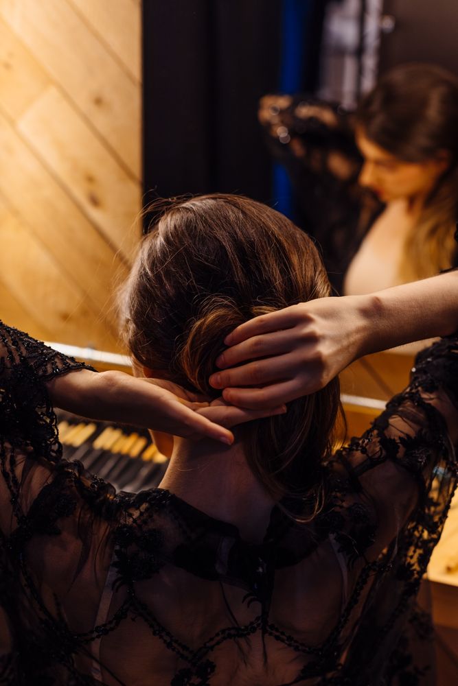 Female actress making hairstyle by illuminated mirror