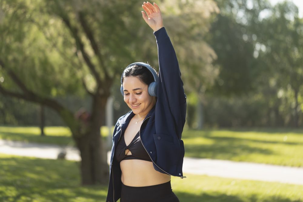 A woman performs exercise and shoulder and arm stretches in the park in the morning