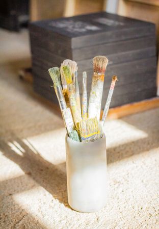 Set of paint brushes in front of canvas