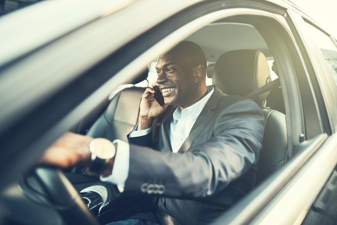 Happy man talking on the phone while driving