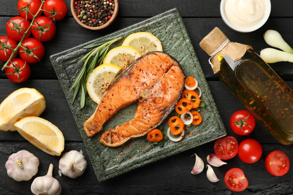 Composition with tasty grilled salmon on wooden background, top view