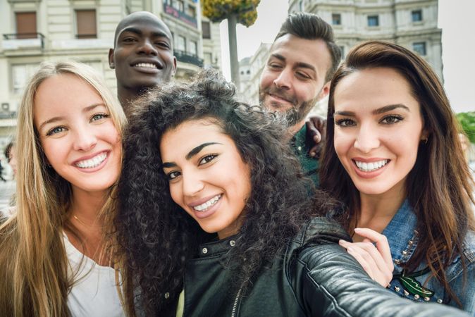 Smiling group of friends looking at camera taking selfie