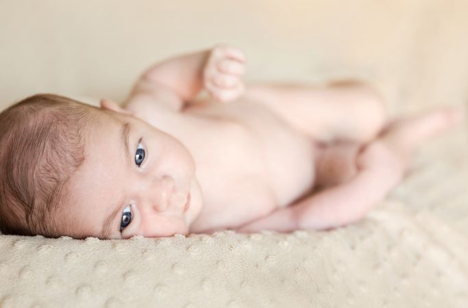 Portrait of newborn baby lying down over a blanket