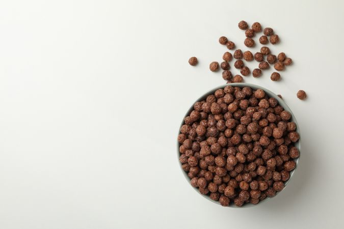 Bowl with corn balls on neutral background, top view