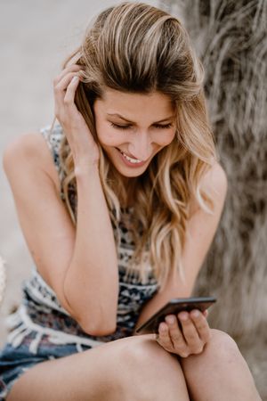 female using smartphone on beach