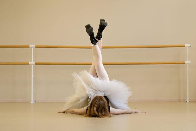 Ballerina in shoes and tutu, performing floor pose