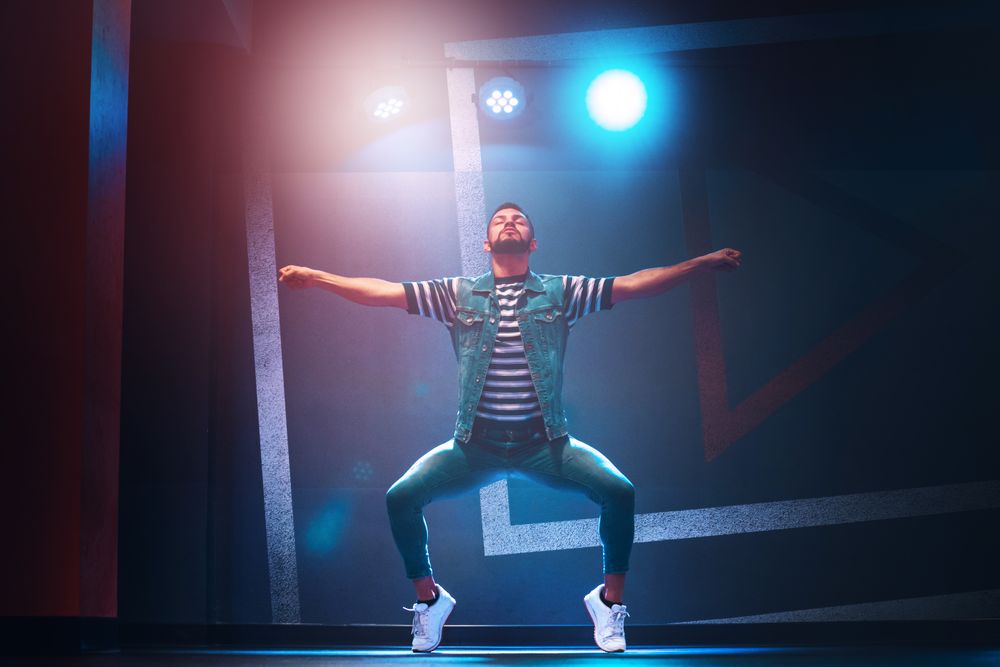 bearded man dancing in spotlight