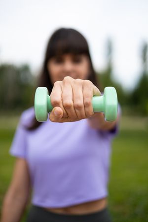 Woman doing weightlifting exercise outdoors