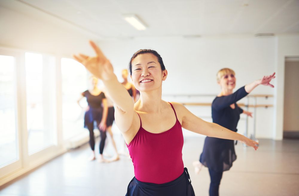 Women with arms outstretched at ballet class