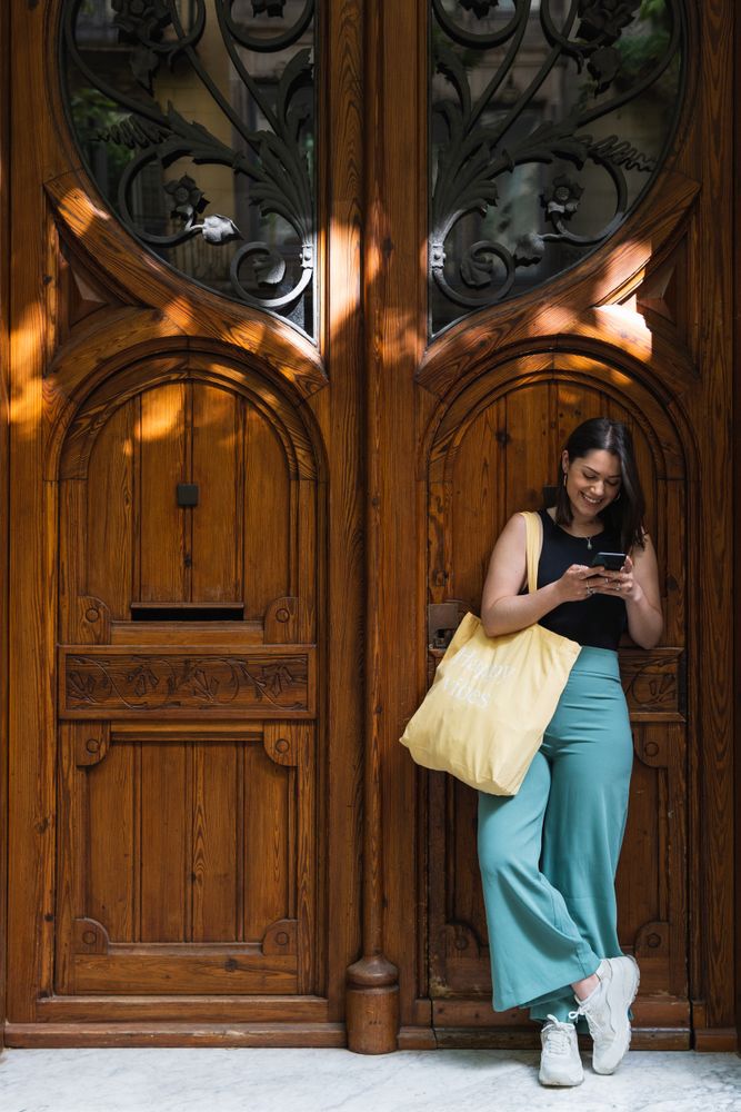 Content stylish woman using smartphone in street