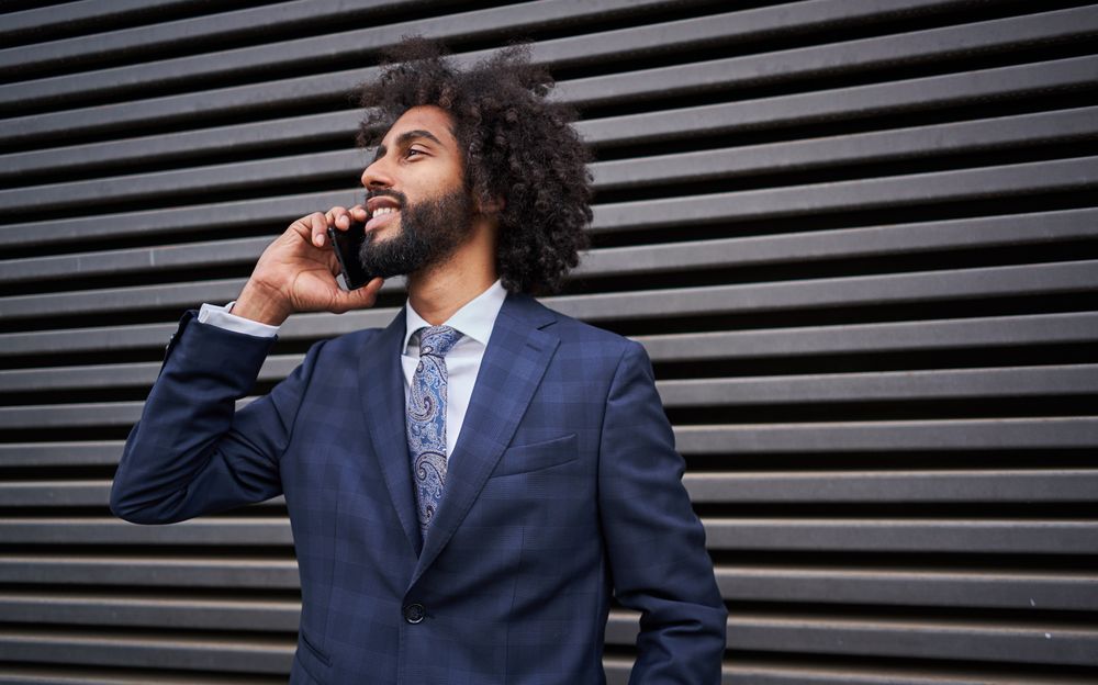 man taking phone near wall