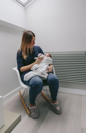 Mother giving bottle to her newborn