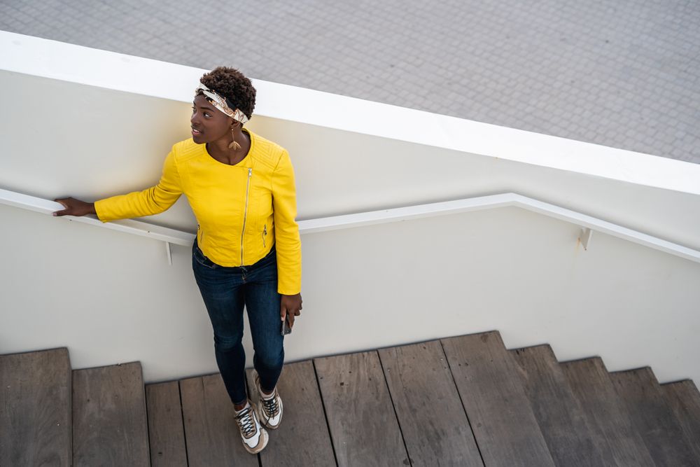 Satisfied female having rest on stairs in city