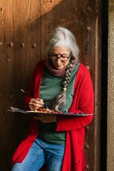 Cheerful painter with paint palette looking at camera