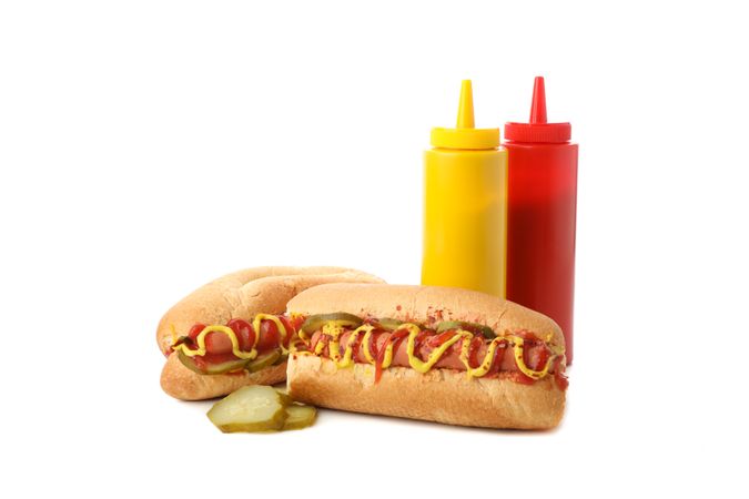 Tasty hot dogs, mustard and ketchup isolated on plain background