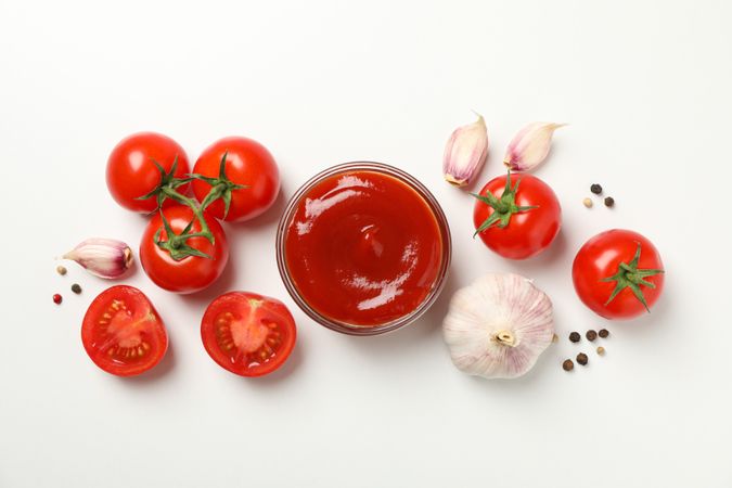Tomatoes, sauce and ingredients on neutral background, top view