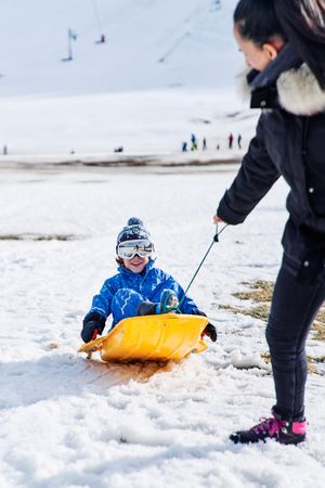 Mother pulling sleigh with child