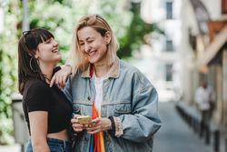 Lesbian couple on the mobile phone on street